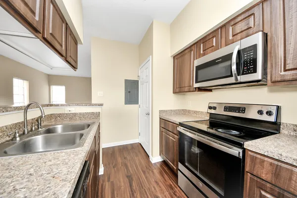 a kitchen with granite countertop a sink cabinets and stainless steel appliances