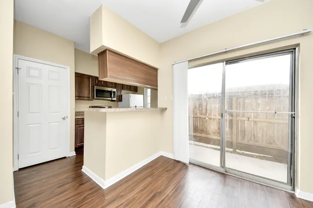 a view of a kitchen with wooden floor and electronic appliances