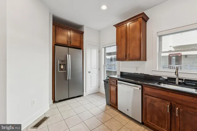 a kitchen with stainless steel appliances granite countertop a sink and a refrigerator