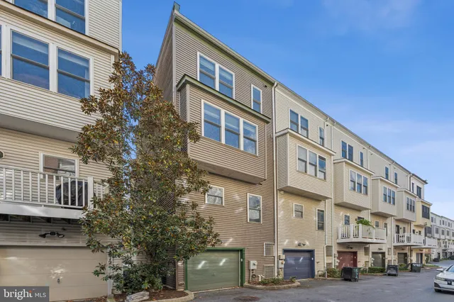 a front view of a building with lot of cars and trees