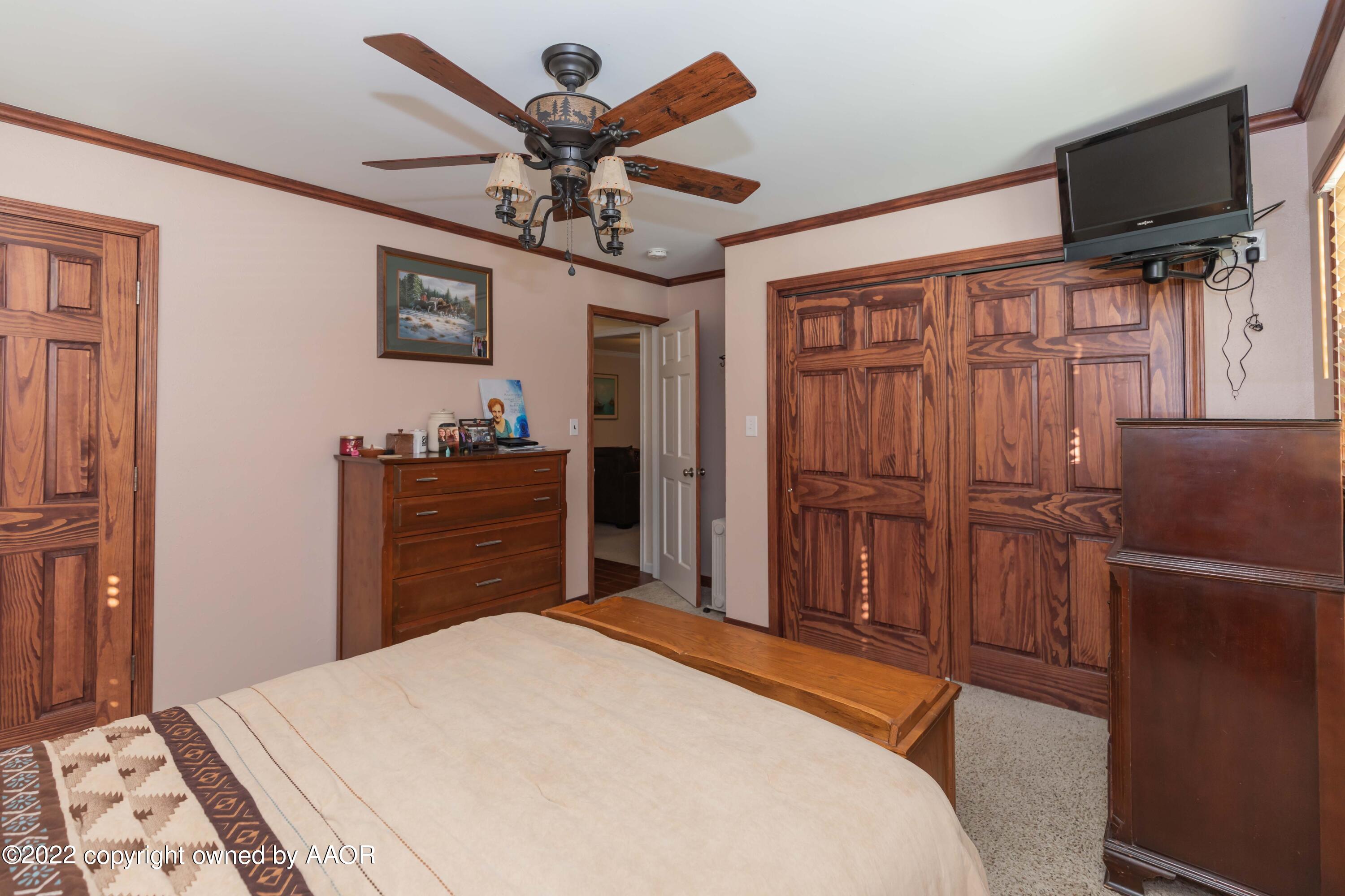 4706 South Bryan Street Amarillo, TX 79110 - Photo 30 of 40 a bedroom with a bed dresser and a flat tv screen