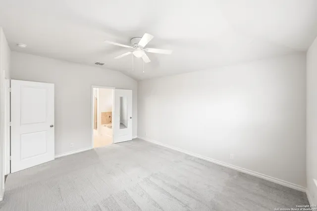 an empty room with a ceiling fan and a window