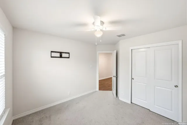 an empty room with fan and windows