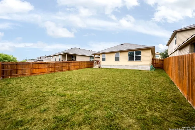 a view of a house with a big yard and large trees