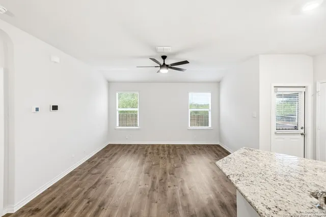 a view of a livingroom with wooden floor and a ceiling fan