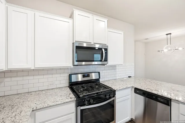 a kitchen with granite countertop a stove and a microwave