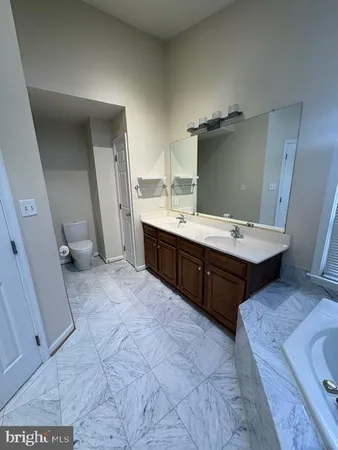 a bathroom with a sink a toilet and a mirror