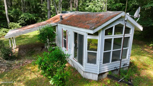 a backyard of a house with large trees and plants