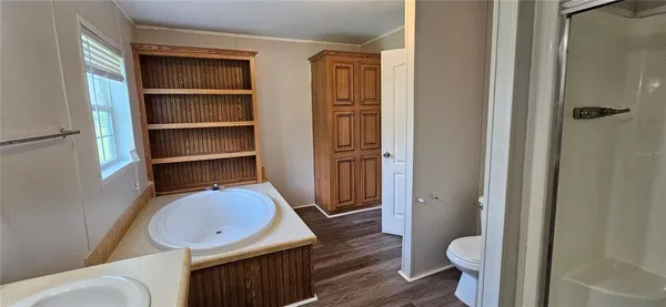 a bedroom with a bed and a flat tv screen on a dresser