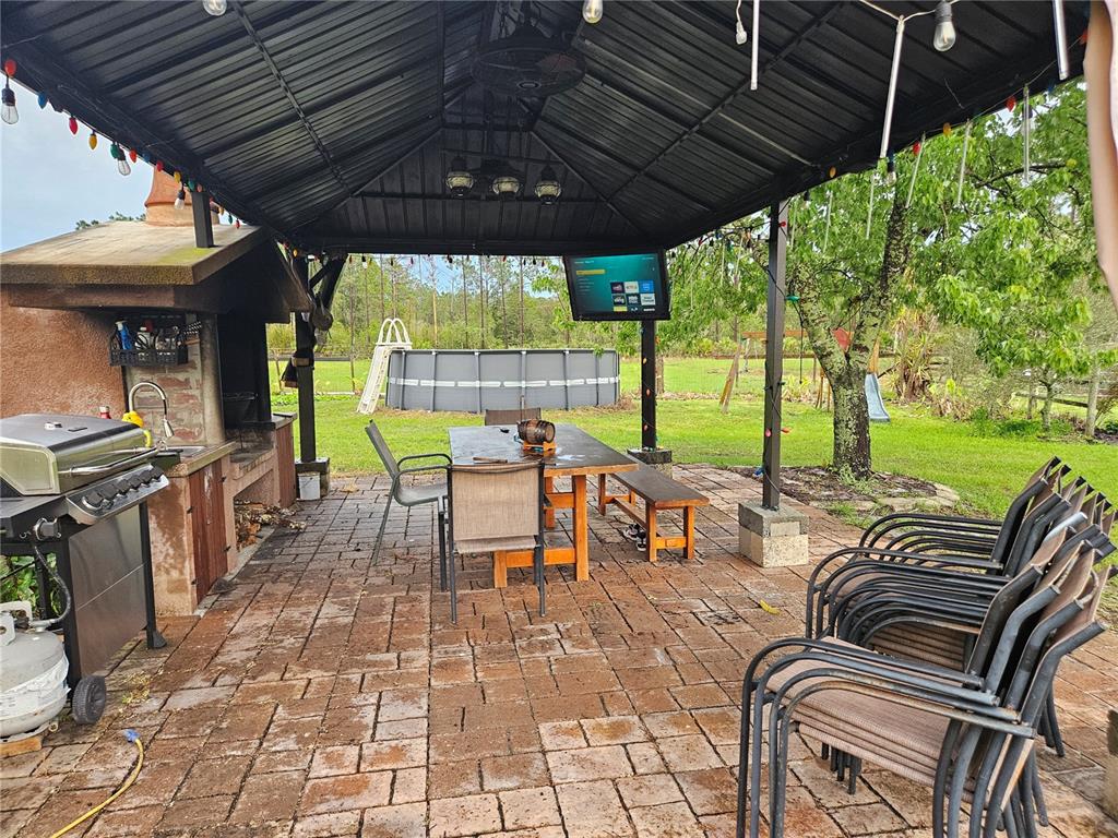 960 Still Road, Unit 1 Pierson, FL 32180 - Photo 48 of 67 a view of a patio with table and chairs under an umbrella with a grill
