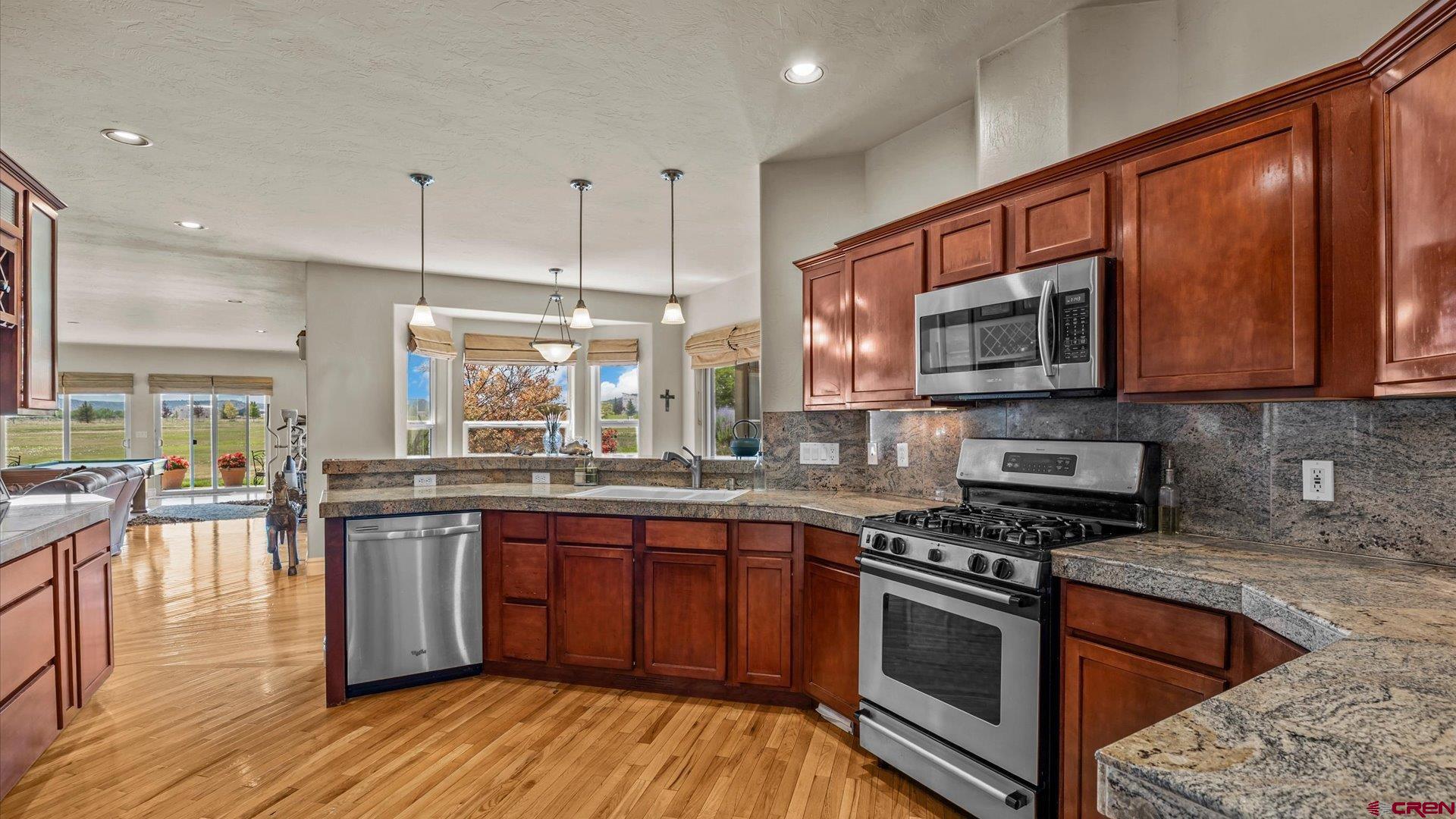 18222 6300th Road Montrose, CO 81403 - Photo 12 of 45 a kitchen with stainless steel appliances granite countertop wooden floors and stove