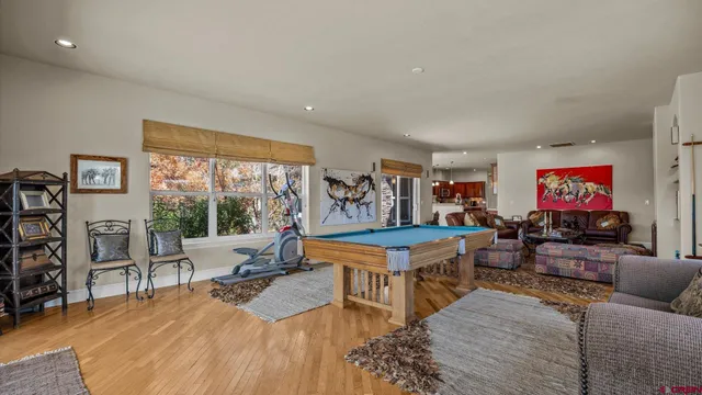 a living room with furniture a flat screen tv and a floor to ceiling window