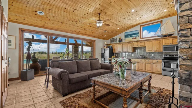 a living room with furniture a fireplace and a dining table with a kitchen view