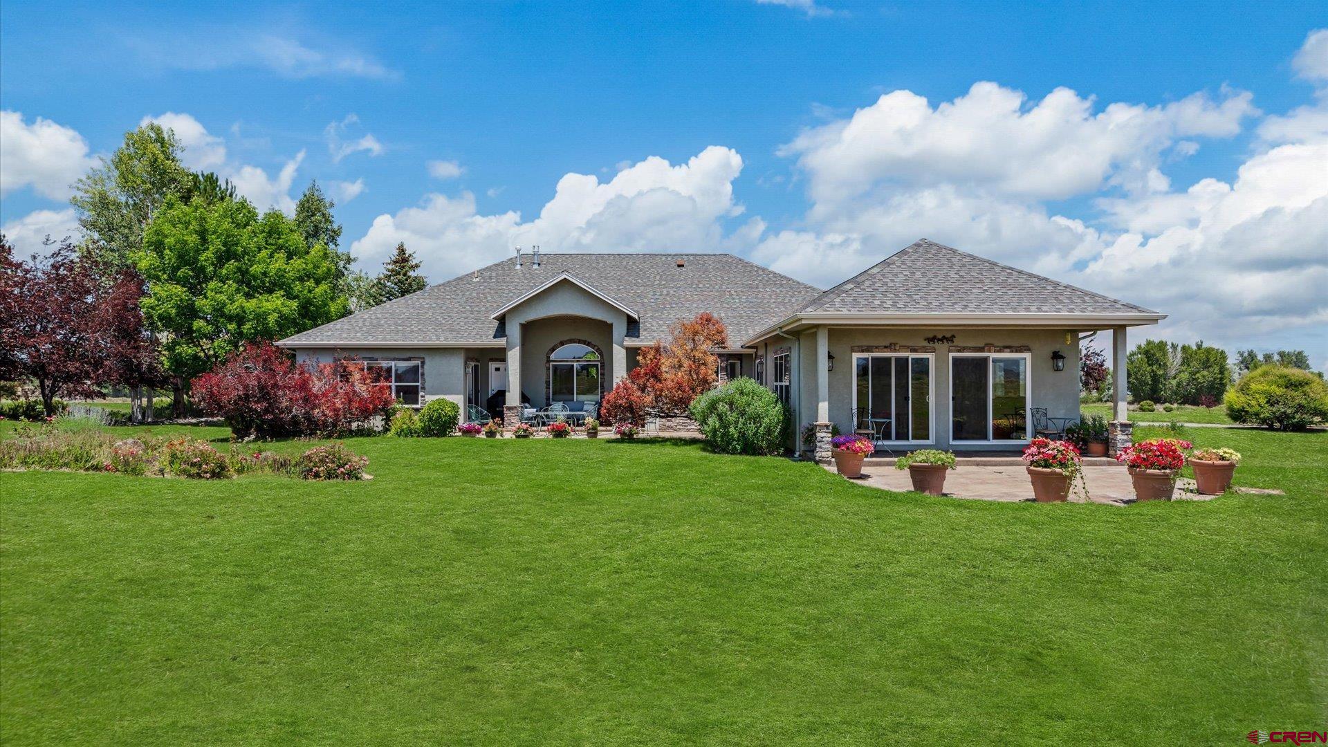 18222 6300th Road Montrose, CO 81403 - Photo 3 of 45 a front view of a house with garden and porch