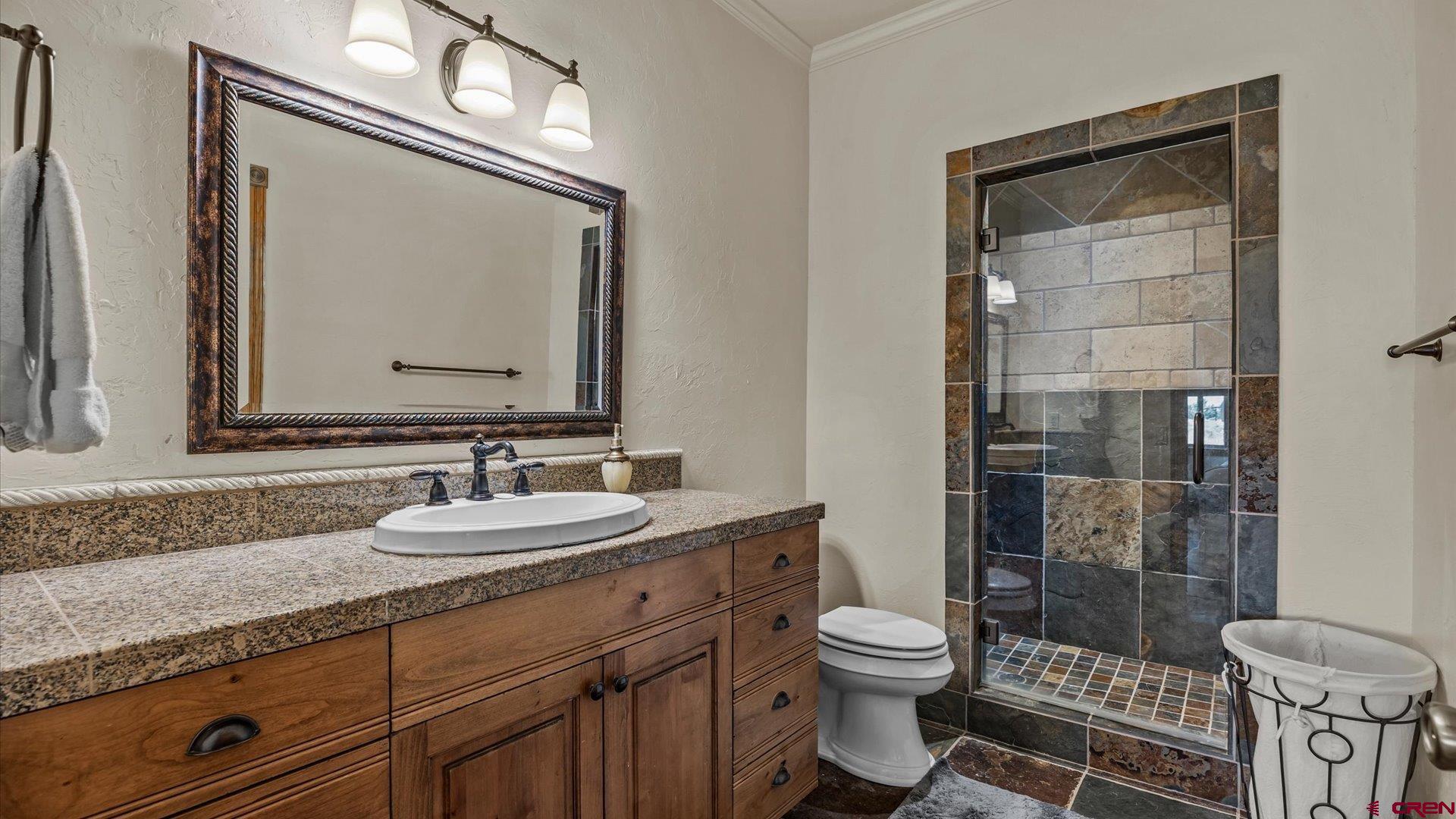 18222 6300th Road Montrose, CO 81403 - Photo 34 of 45 a bathroom with a granite countertop toilet a sink and a mirror