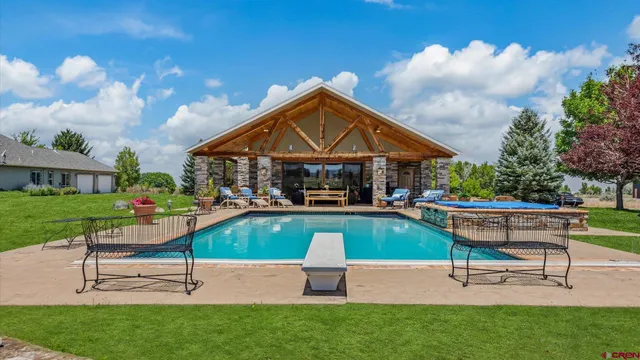 a view of pool with lawn chairs and a fire pit