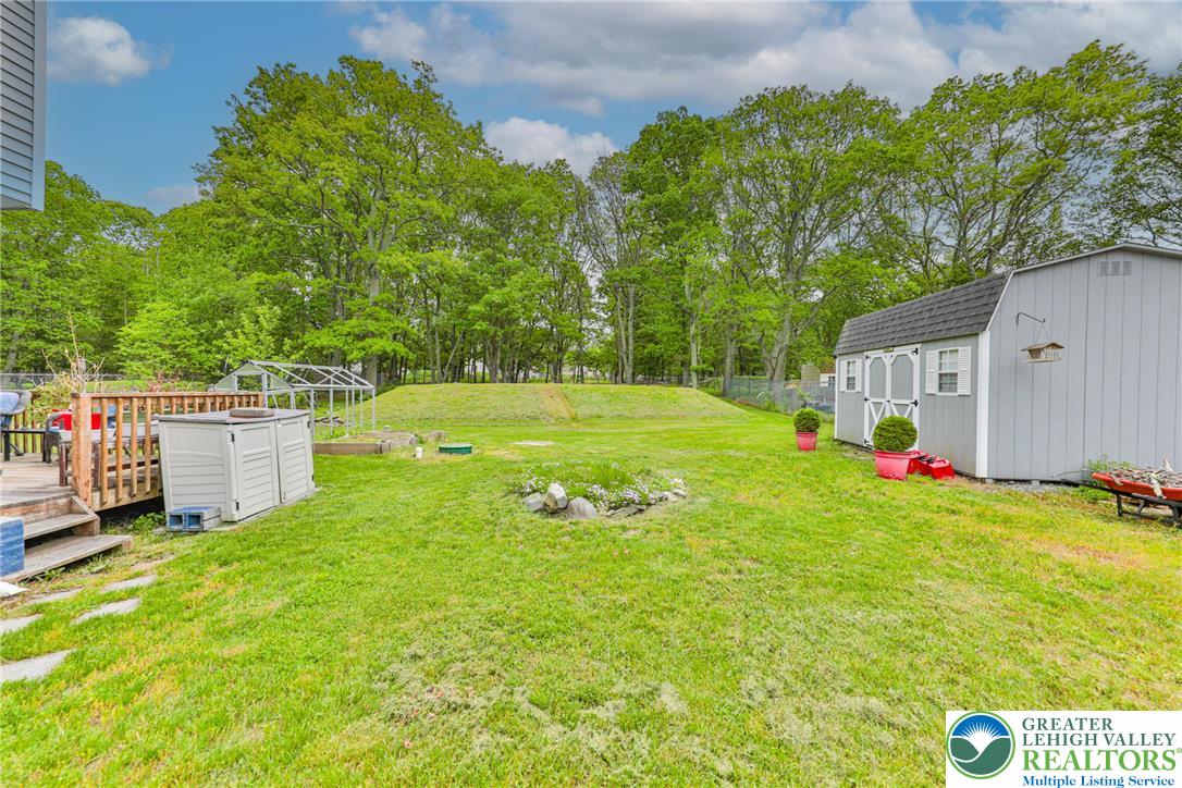 4608 Pine Ridge Drive West Bushkill, PA 18324 - Photo 47 of 62 A spacious yard with mature trees offers a dedicated garden space and a practical storage shed.