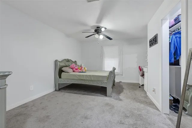 a bedroom with furniture and a chandelier fan