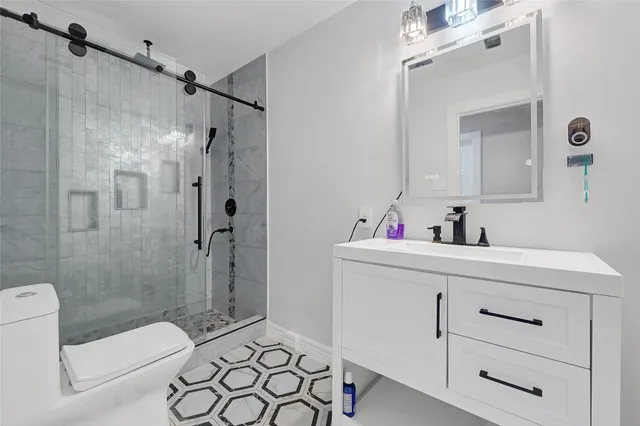 a bathroom with a sink mirror vanity and toilet