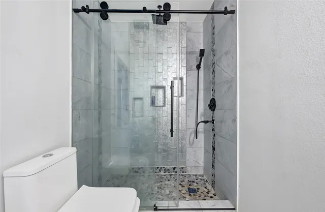 a bathroom with a toilet and a shower