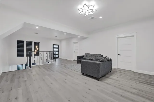 a living room with furniture and a wooden floor