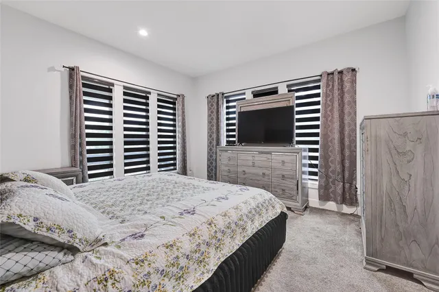 a bedroom with a bed dresser and a flat screen tv