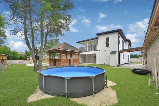 a view of a backyard with table and chairs under an umbrella