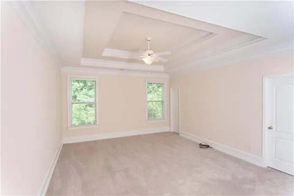an empty room with windows and ceiling fan