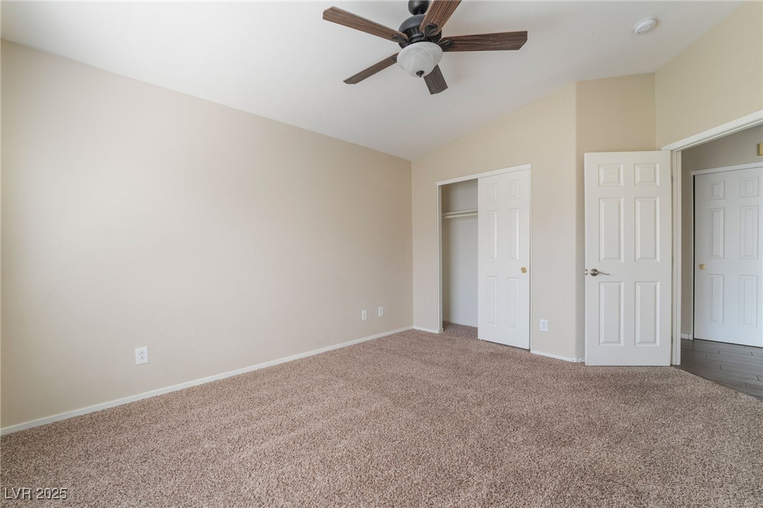 1570 Rusty Ridge Lane Henderson, NV 89002 - Photo 32 of 35 Unfurnished bedroom with a closet, baseboards, a ceiling fan, lofted ceiling, and carpet