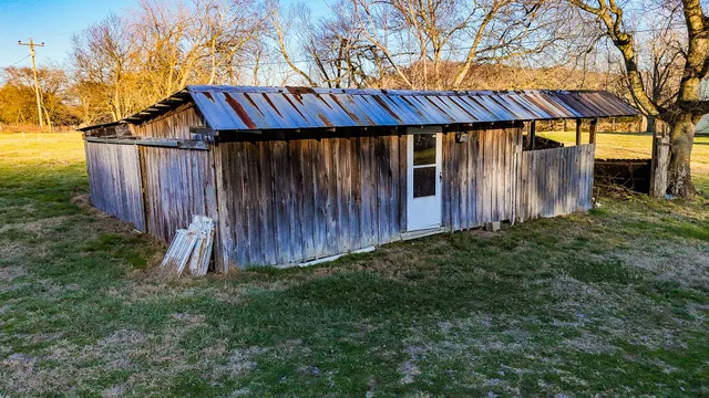a view of a back yard with wooden fence