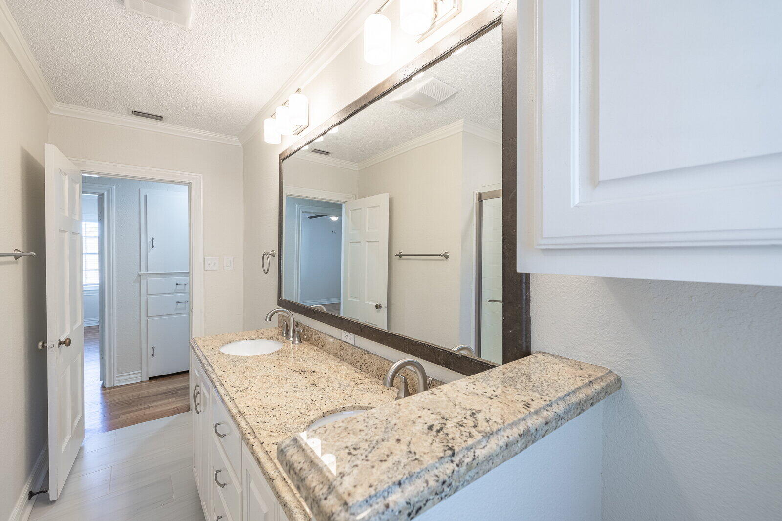 2810 24th Street Lubbock, TX 79410 - Photo 26 of 47 a en suite bathroom with a granite countertop sink and a mirror