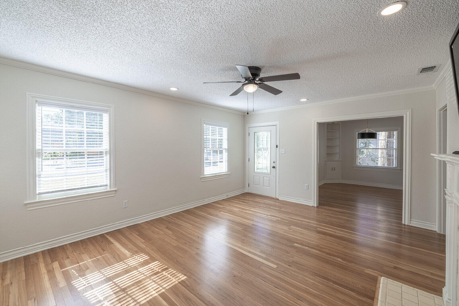 2810 24th Street Lubbock, TX 79410 - Photo 6 of 47 a view of an empty room with a window and wooden floor