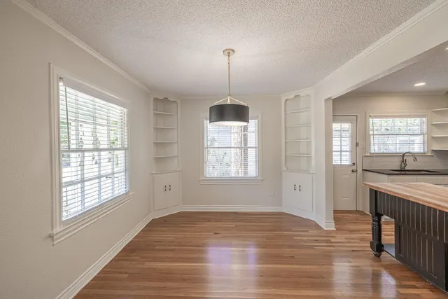a view of a room with wooden floor and a ceiling fan