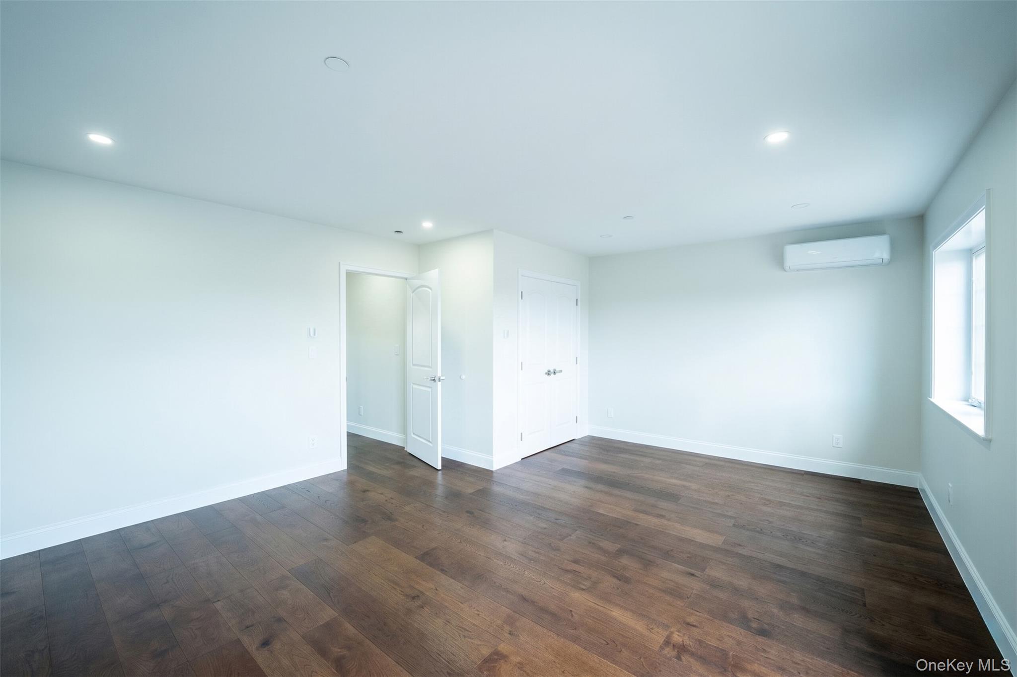 150-26 12th Road Queens, NY 11357 - Photo 12 of 17 an empty room with wooden floor and windows