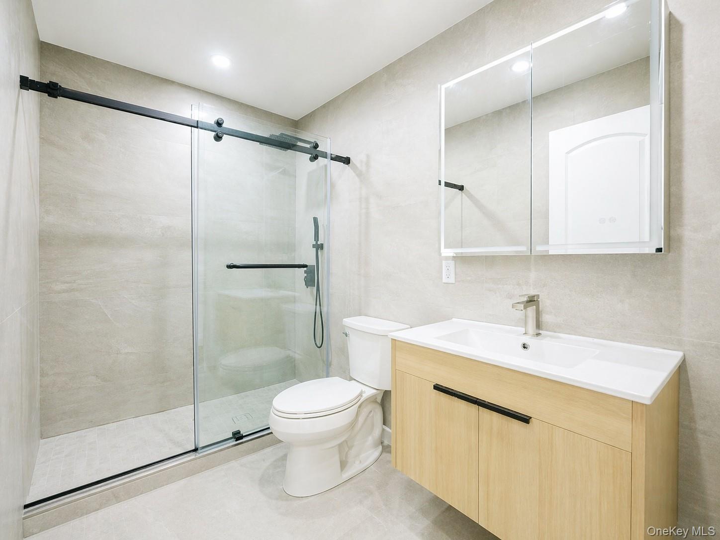 150-26 12th Road Queens, NY 11357 - Photo 16 of 17 a bathroom with a shower sink vanity and toilet