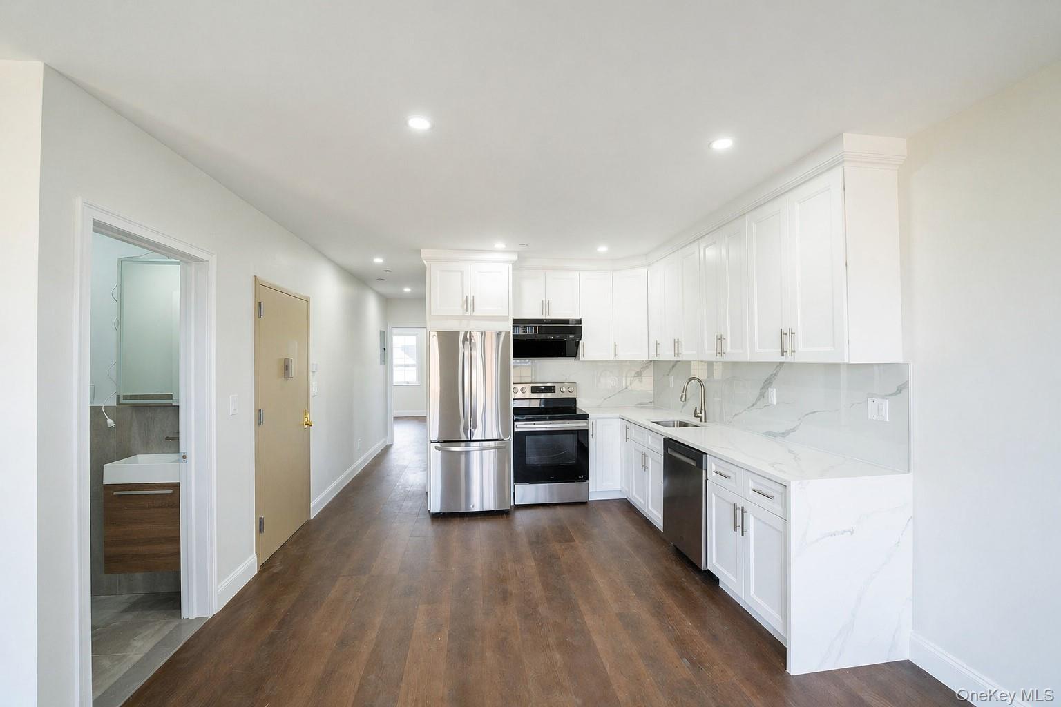 150-26 12th Road Queens, NY 11357 - Photo 6 of 17 a kitchen with stainless steel appliances granite countertop a stove top oven a sink and a refrigerator
