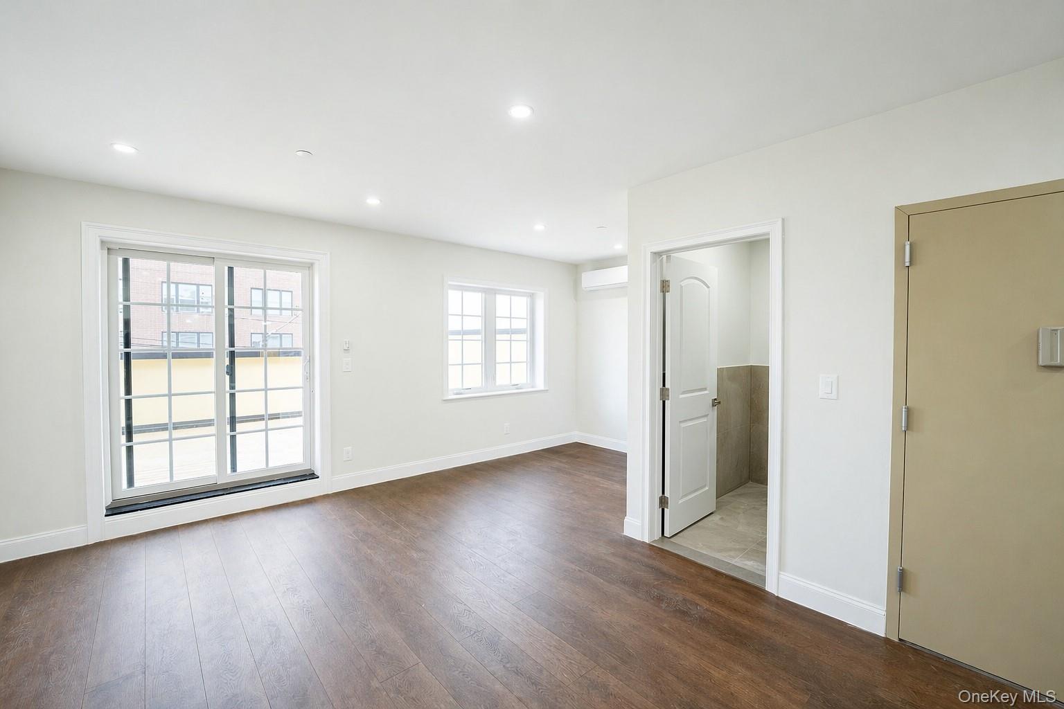 150-26 12th Road Queens, NY 11357 - Photo 7 of 17 an empty room with wooden floor and windows
