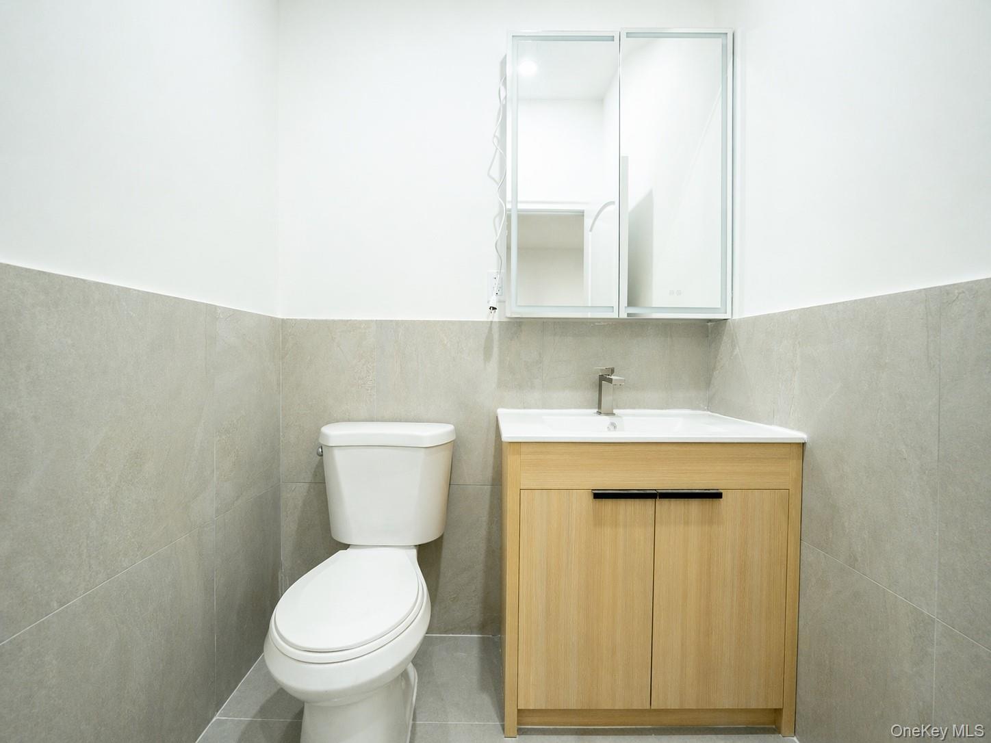 150-26 12th Road Queens, NY 11357 - Photo 8 of 17 a bathroom with a toilet sink and mirror