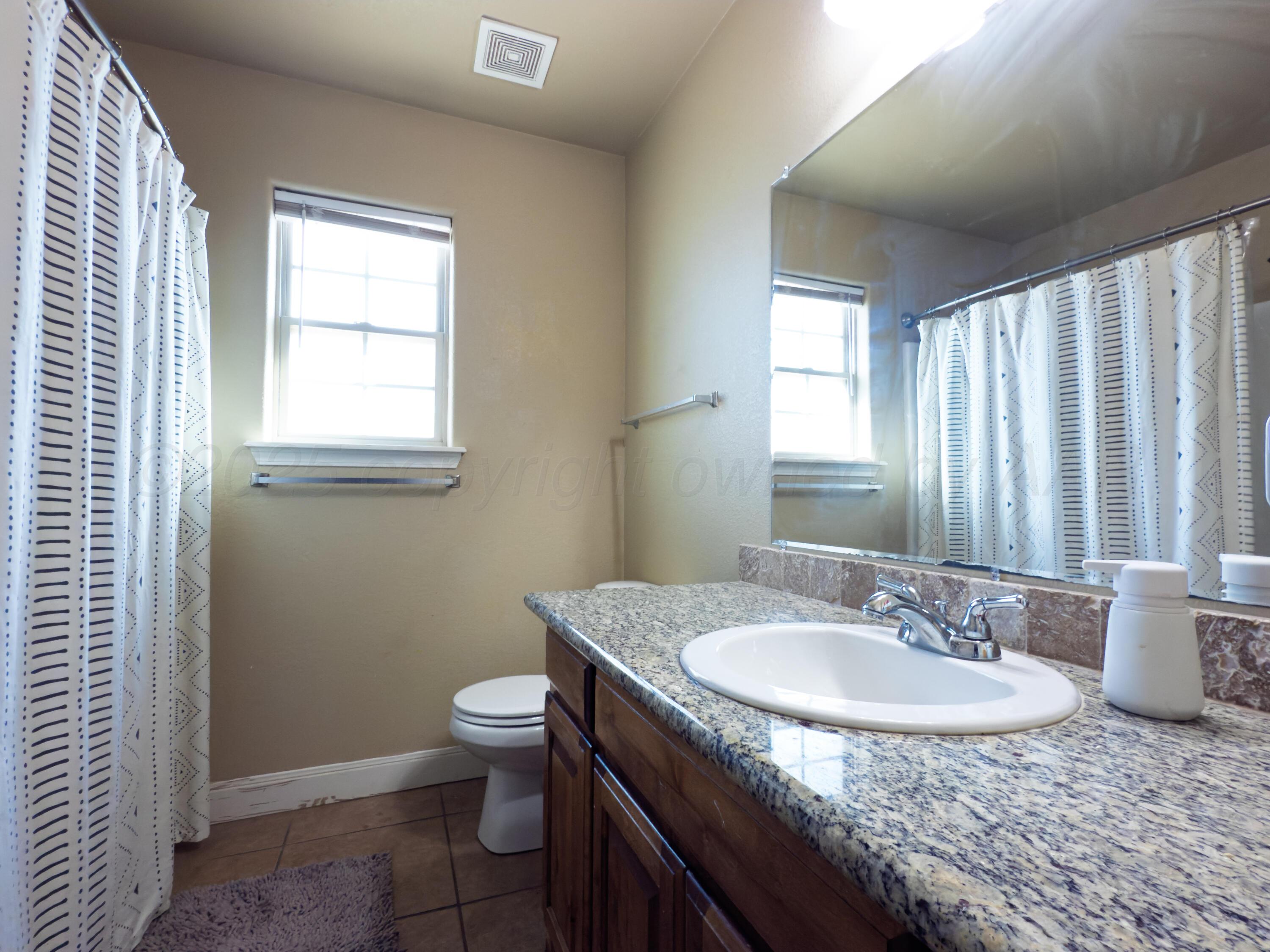 3701 Arden Road Amarillo, TX 79118 - Photo 11 of 18 a sink and a toilet sitting in a bathroom