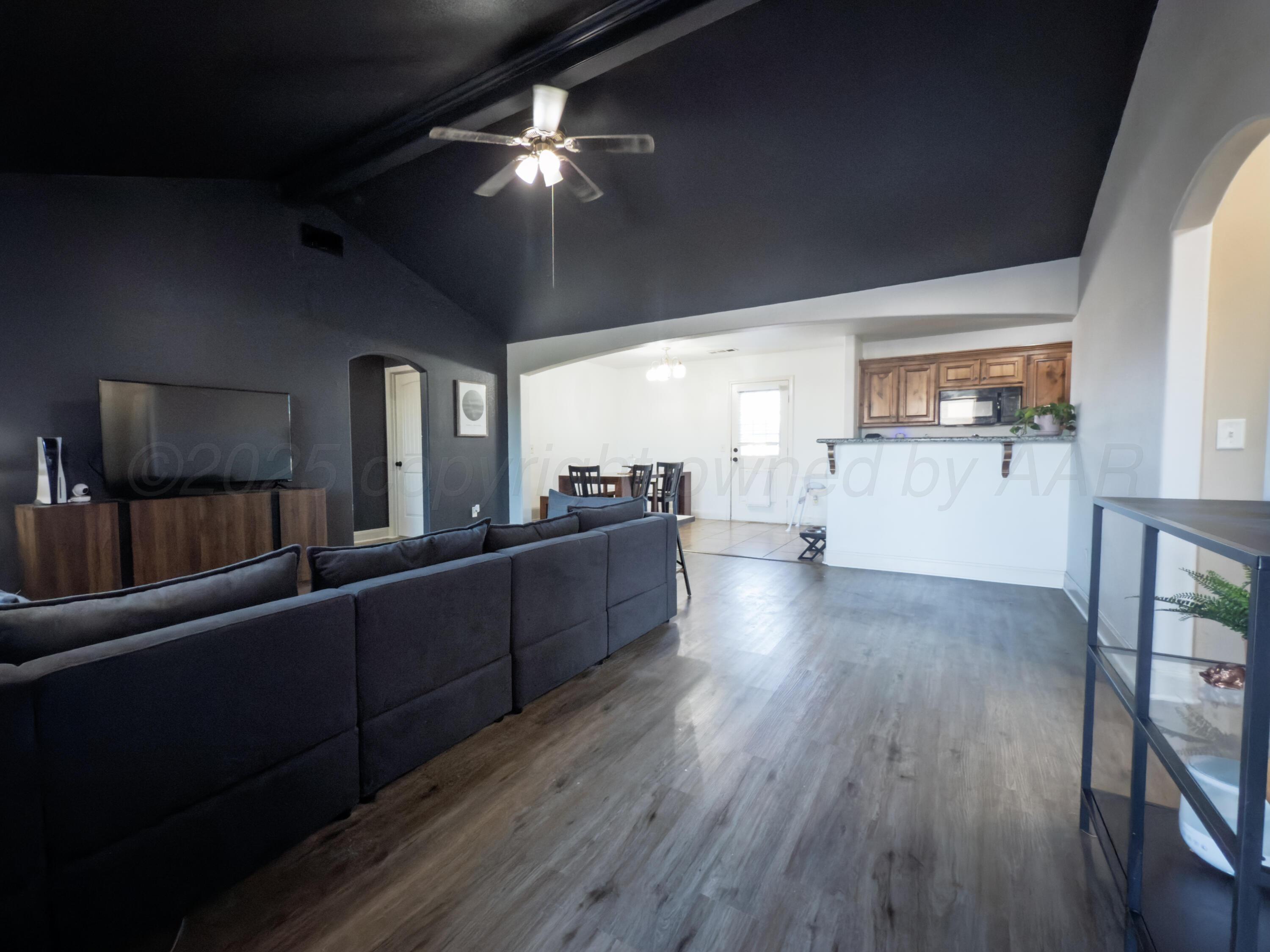 3701 Arden Road Amarillo, TX 79118 - Photo 3 of 18 a kitchen with stainless steel appliances granite countertop a refrigerator a sink dishwasher a stove and a dining table with wooden floor