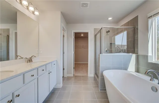 a bathroom with a tub sink and mirror