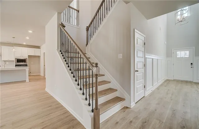 a view of staircase with wooden floor and a chandelier