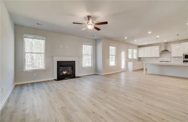 a view of an empty room with a window and fireplace
