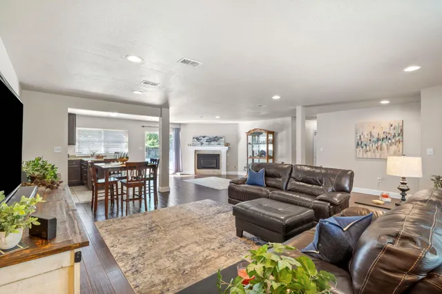 a kitchen with stainless steel appliances granite countertop a stove top oven a sink dishwasher and a refrigerator with wooden cabinets