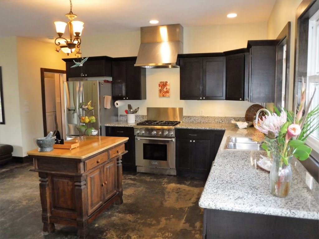 1209 West Kuiaha Road, Unit 2 Haiku, HI 96708 - Photo 4 of 30 a kitchen with kitchen island granite countertop a sink a counter top space a stove and cabinets
