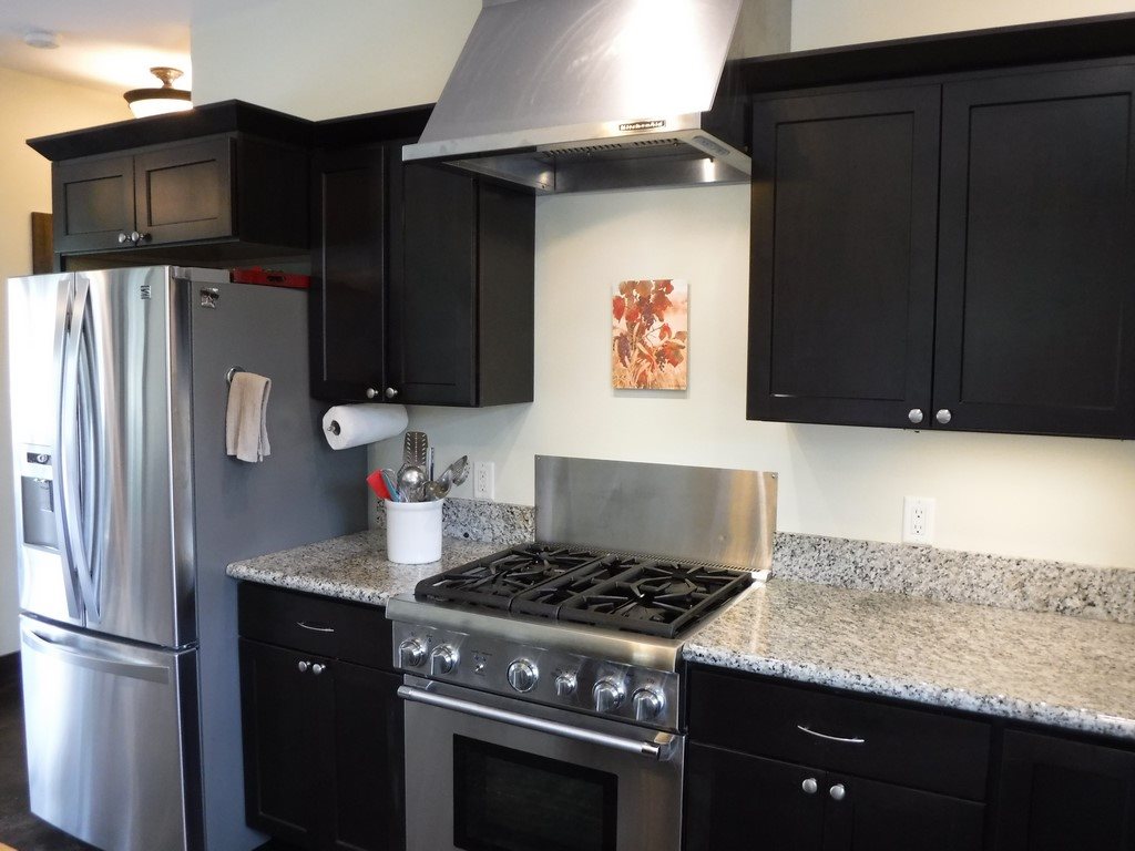 1209 West Kuiaha Road, Unit 2 Haiku, HI 96708 - Photo 10 of 30 a kitchen with granite countertop stainless steel appliances and wooden cabinets
