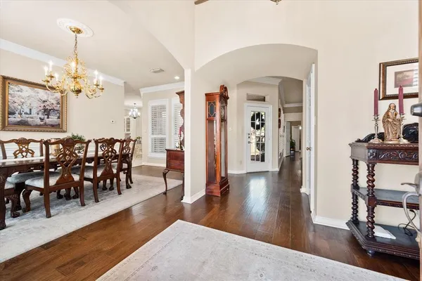 a view of a dining room with furniture a chandelier and wooden floor