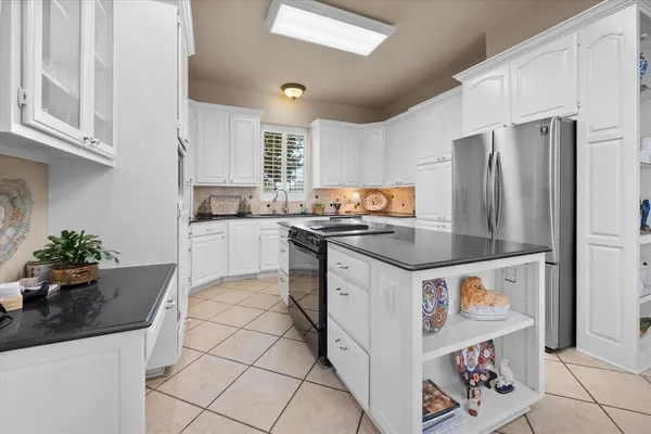 a kitchen with stainless steel appliances kitchen island granite countertop a refrigerator and a stove