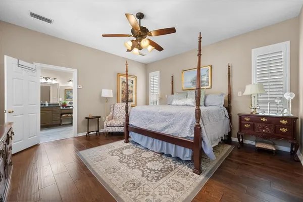a spacious bedroom with a large bed a chandelier and a window