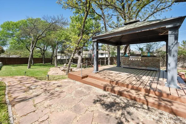 a view of backyard with a table and chairs under an umbrella